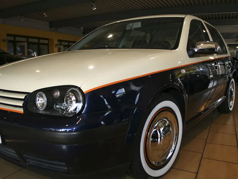 Zweifarbig folierter Kompaktwagen in Creme und Dunkelblau mit orangefarbener Linie