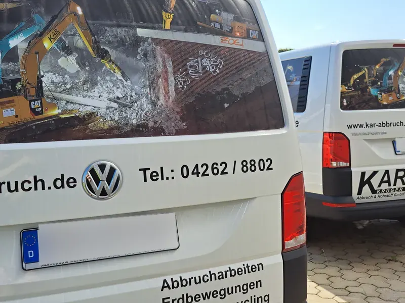 Heckscheibe eines Transporters mit bedruckter Folie und Firmenbeschriftung