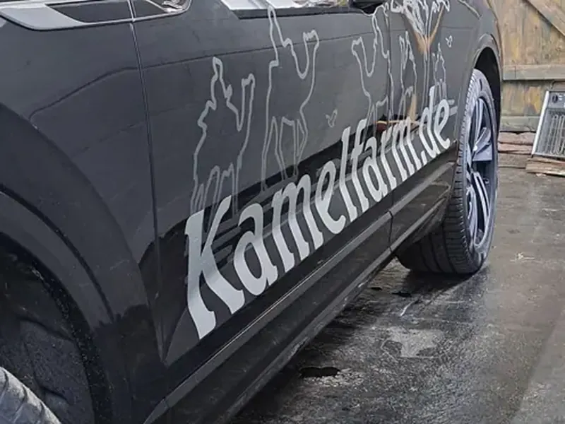 Dunkler Geländewagen mit Schriftzug auf der Seite