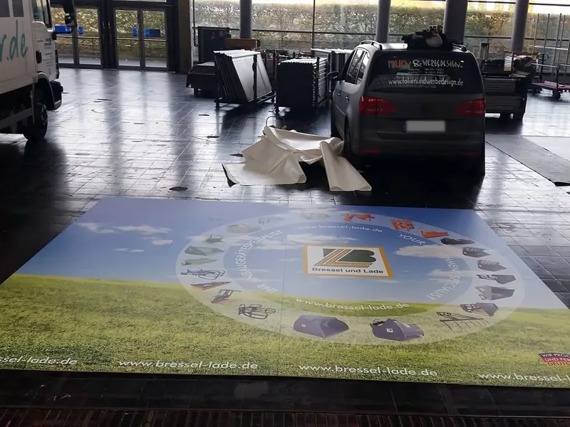 Großflächiger Bodendruck mit Firmenlogo und Wiesenmotiv auf einem Messestand
