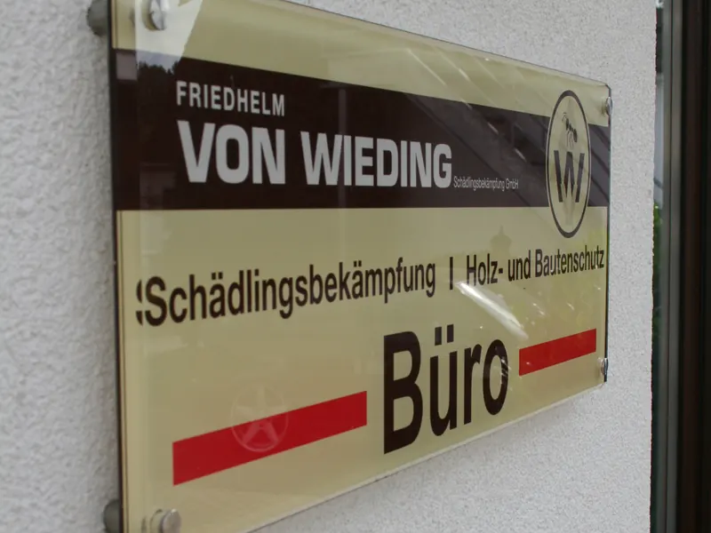 Acrylglasschild mit Firmenlogo und dem Schriftzug Büro, mit Abstandshaltern an einer Hauswand montiert