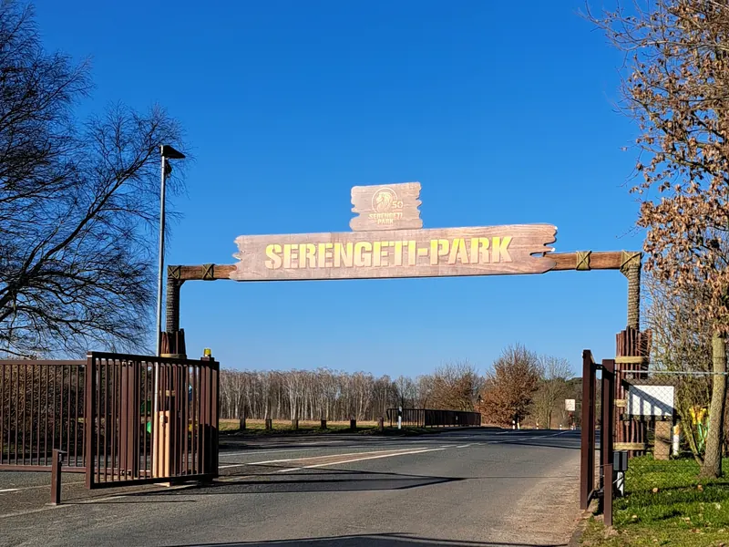 Torbogen an der Einfahrt eines Freizeitparks mit Schild in Holzoptik