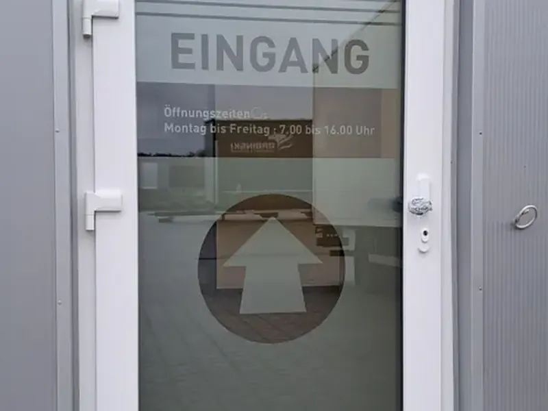 Eingangstür mit Milchglasfolie und Schriftzug