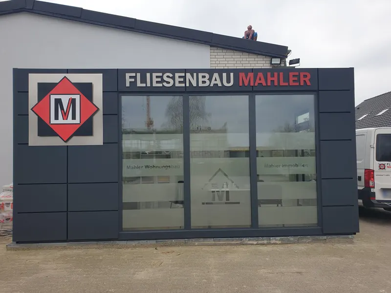 Firmenfassade mit Schriftzug, Logo und Milchglasstreifen auf den Scheiben